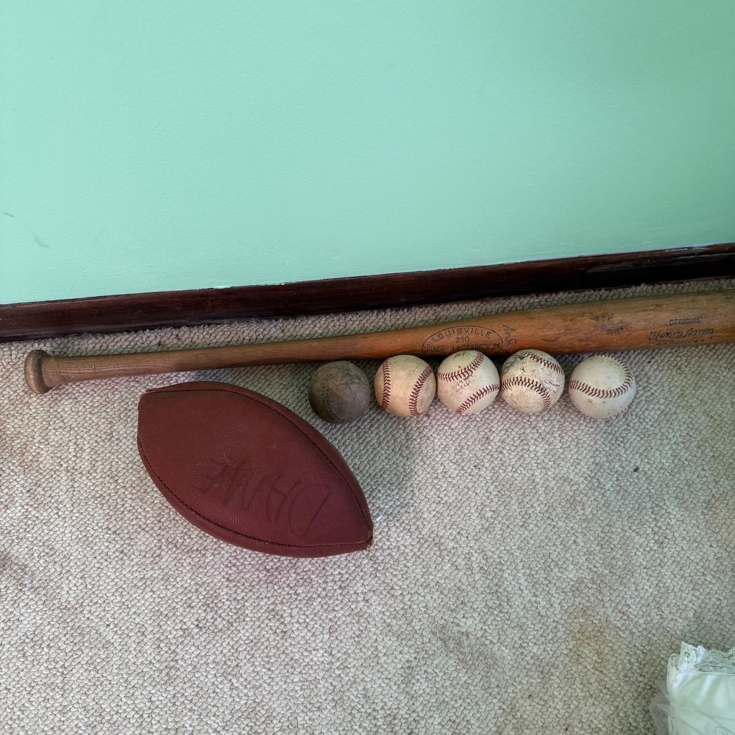 Vintage Louisville bat, baseballs and football Vintage Louisville bat, baseballs and football