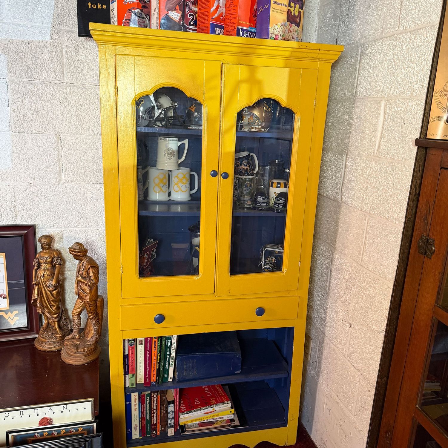 Tall one-piece solid wood display kitchen cabinet with glass panels, WVU blue and gold, front doors close but slightly misaligned, see photos 68"H x 32"L x 14"D (Heavy & in the lower level)
