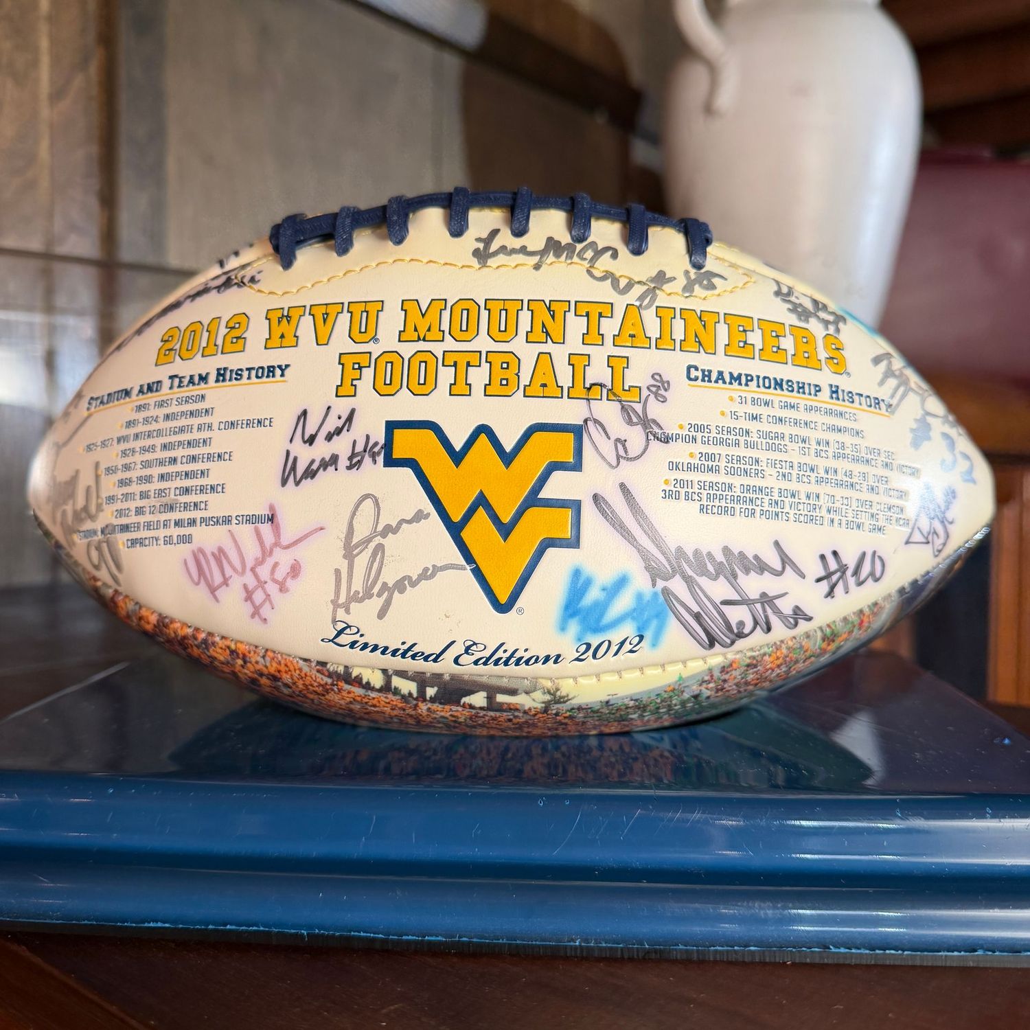Football in case #6 WVU with multiple signatures including Dana Halgorsen, Shawne White, Mark Glowinski, Javon Austin,