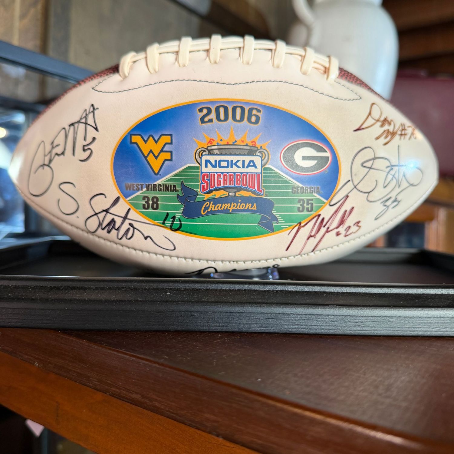 Football in case #7 with multiple signatures including Pat White, Steve Slayton, Owen Schmitt, and more