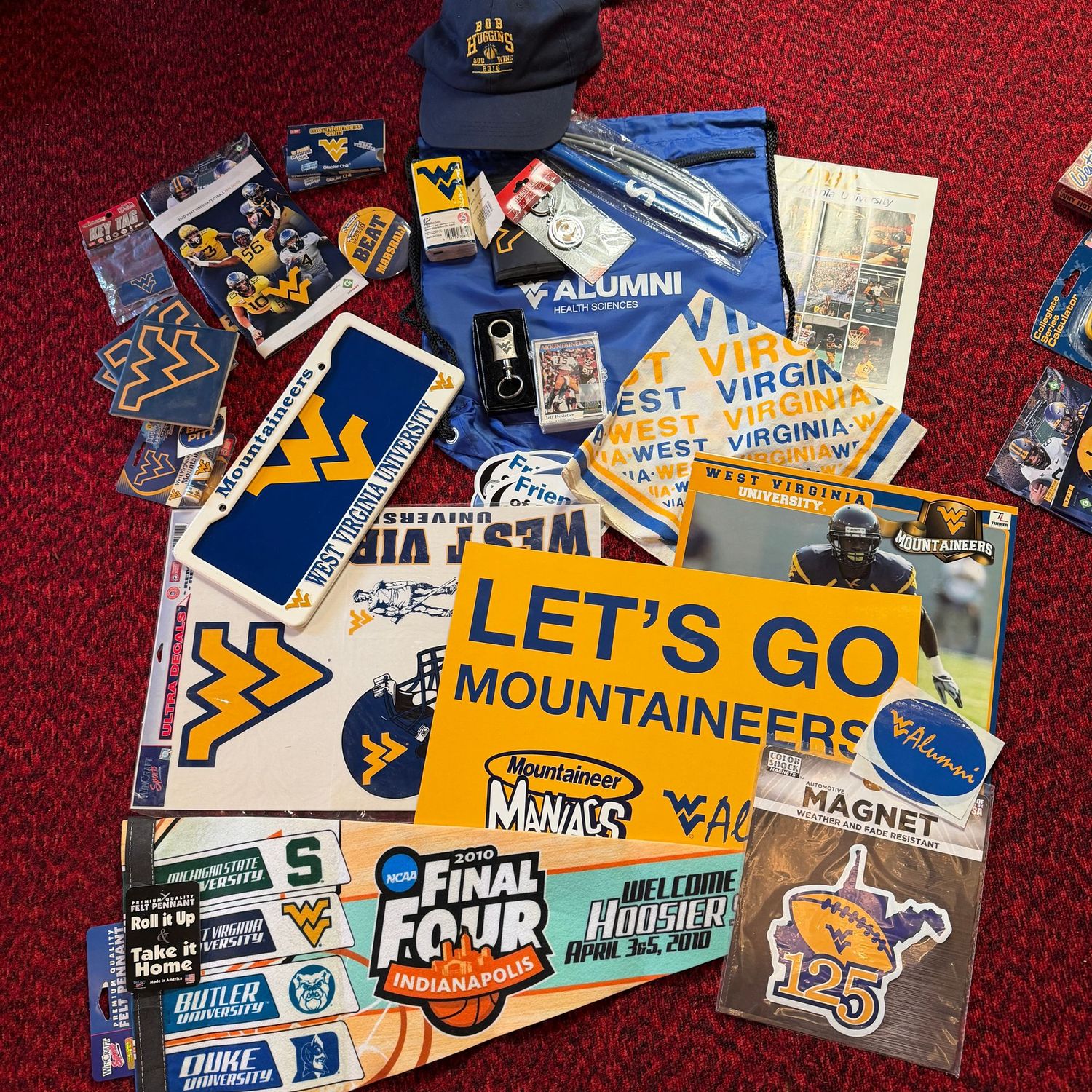 Sports Memorabilia Lot G, including WVU pennant, banners, blue license plate, hat, coasters, magnet, decals & more