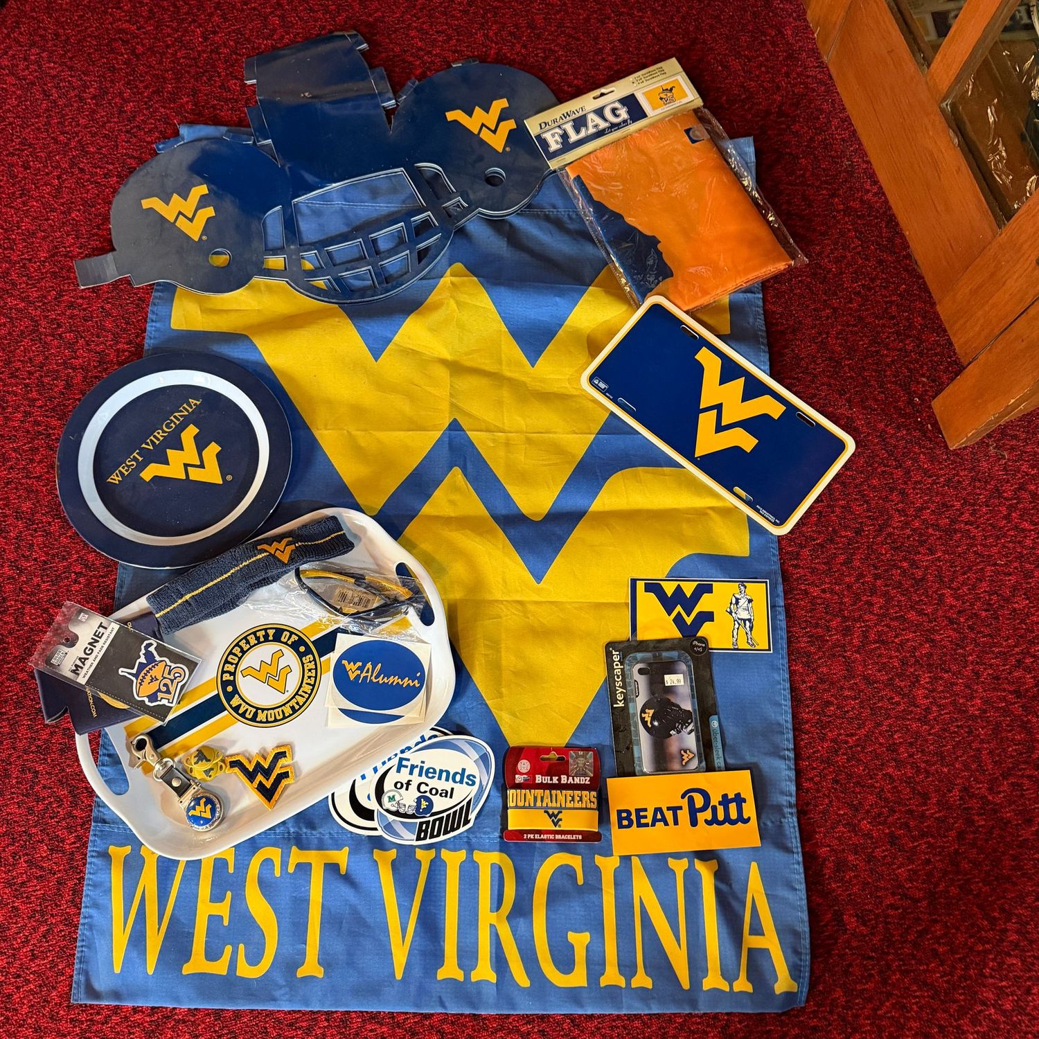 Sports Memorabilia Lot D including WVU flags, plastic trays, stickers, key ring, sunglasses, plastic license plate, paper helmet decorations