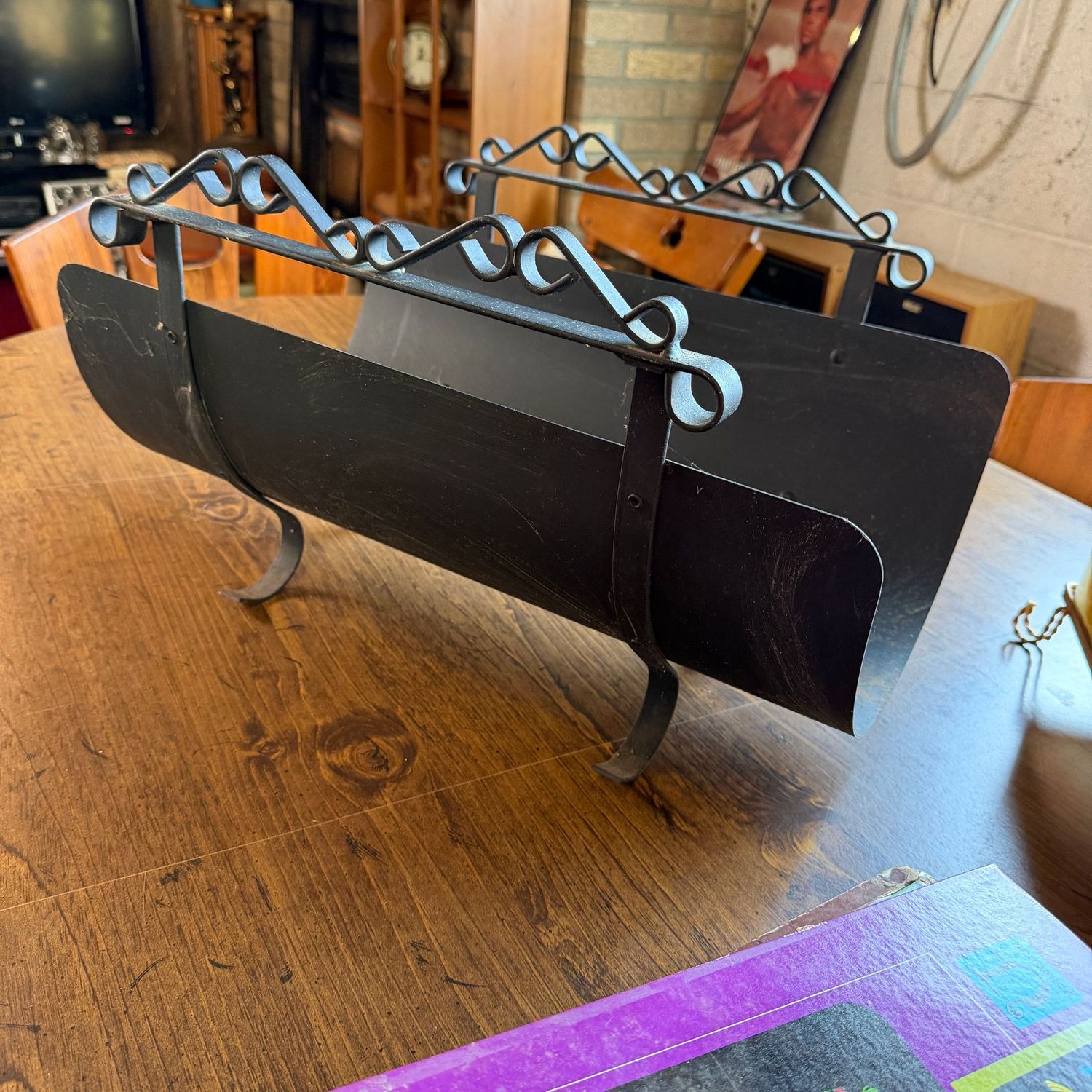 Black metal log holder with wrought iron handles and legs, minor wear, 19"L