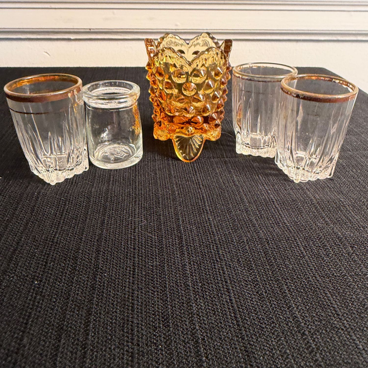 Grouping of small shot glasses and Fenton amber hobnail toothpick holder