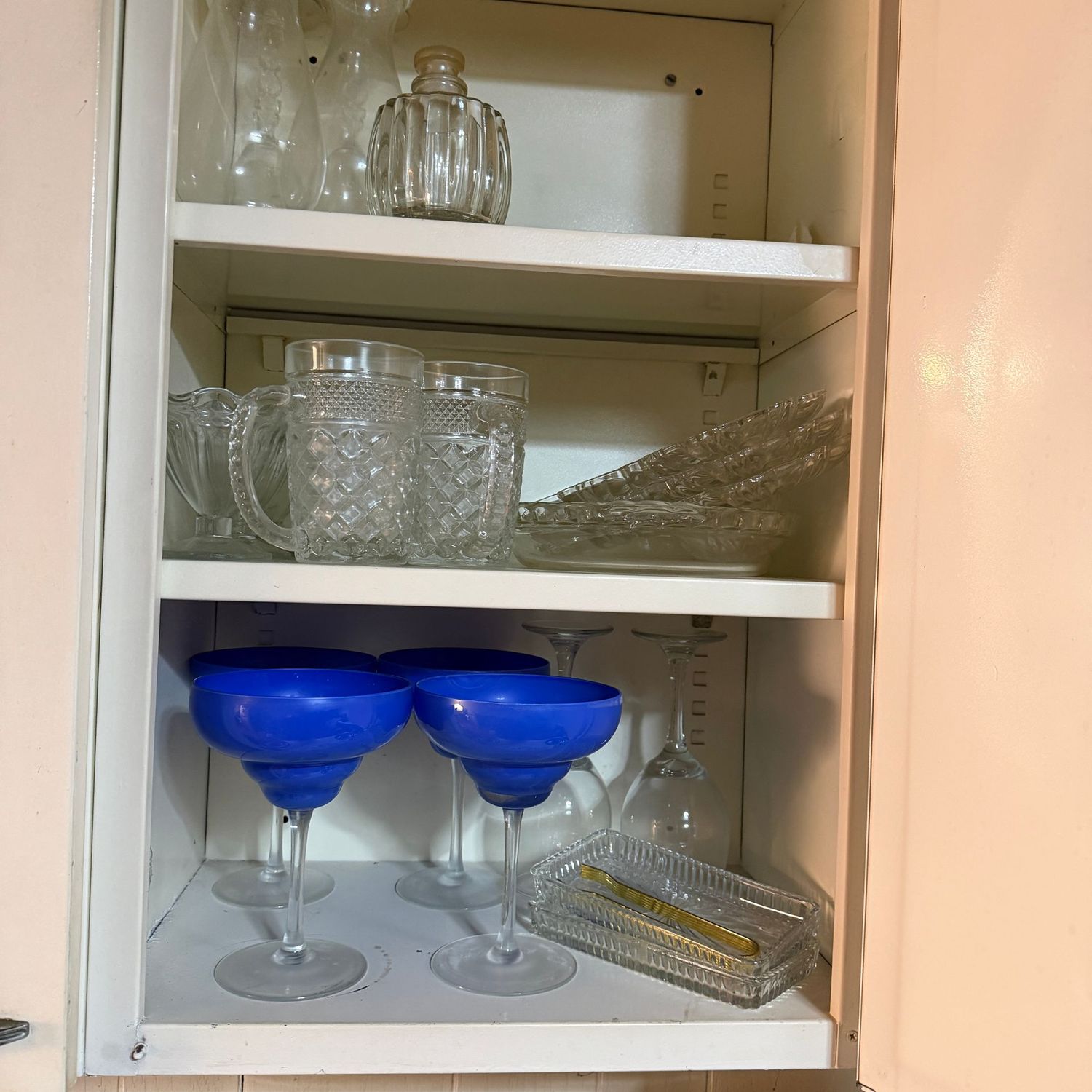 Cabinet contents with drinkware, small trays, pie pan