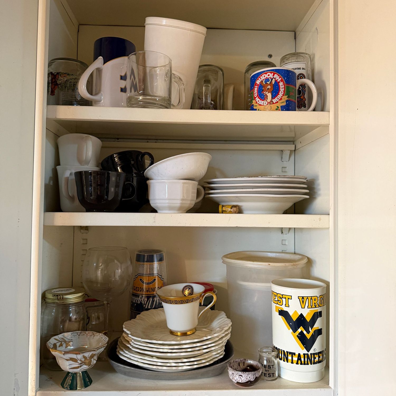 Cabinet contents with coffee cups, bowls, plates