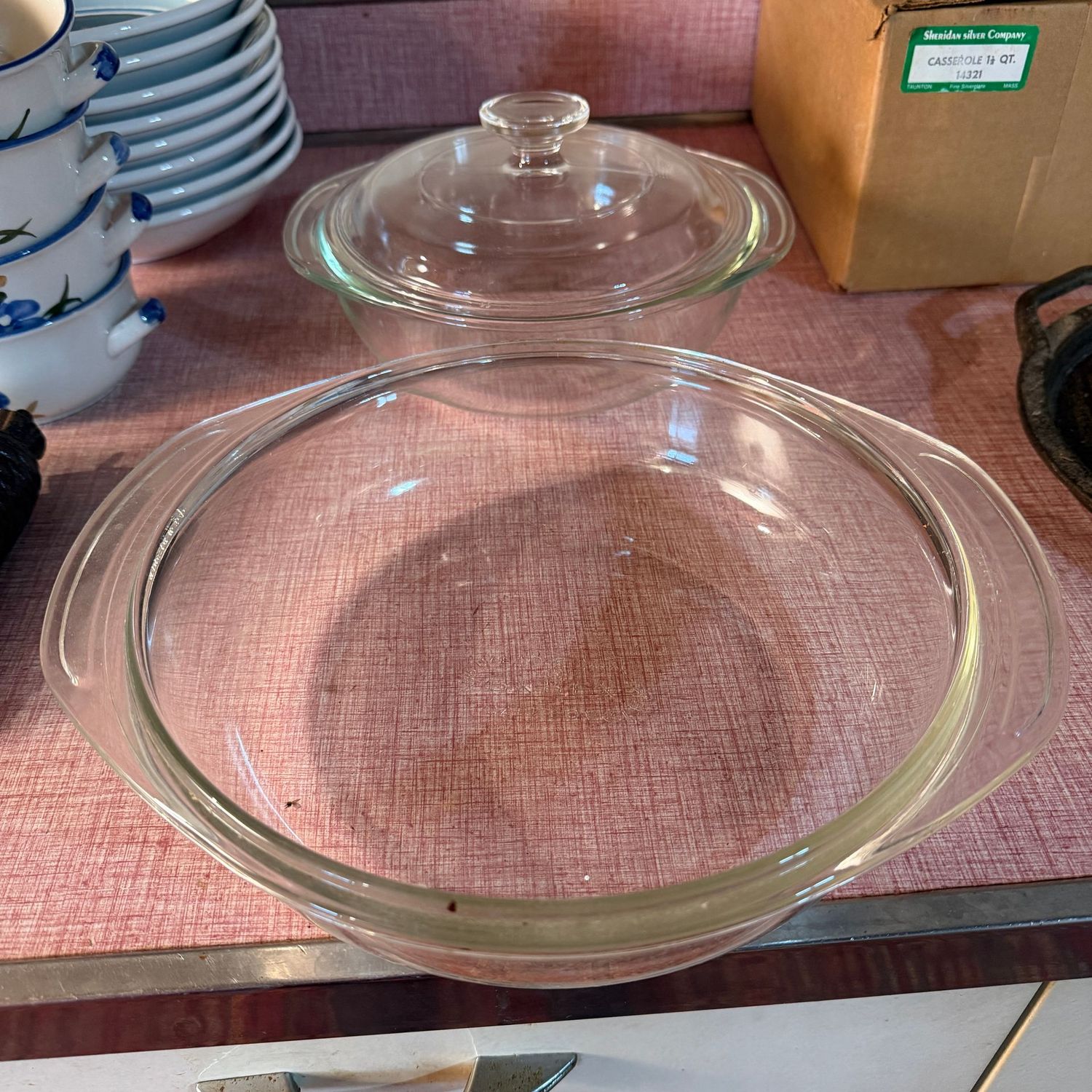 Two clear glass casseroles, the largest is 10"W
