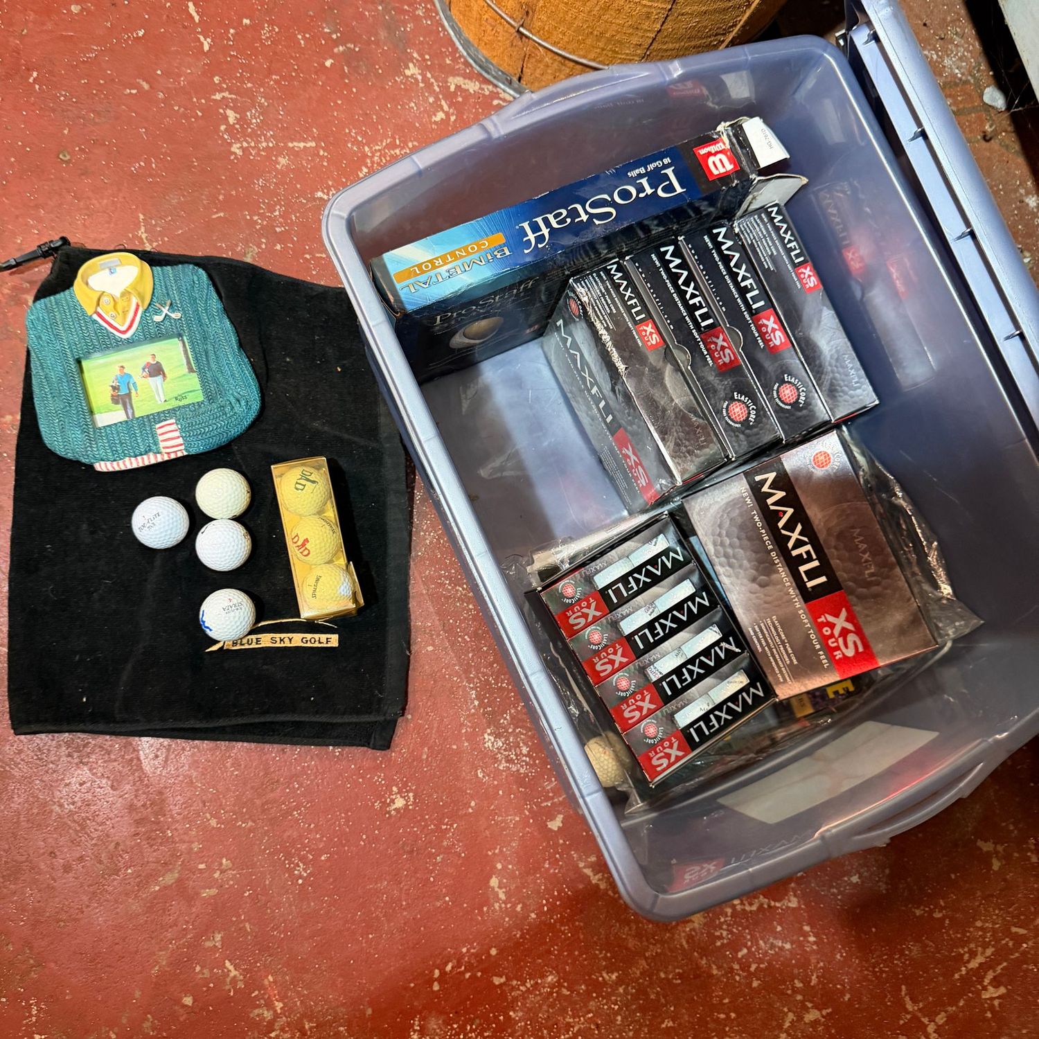Bin with lid filled with golf items, magazines, golf balls