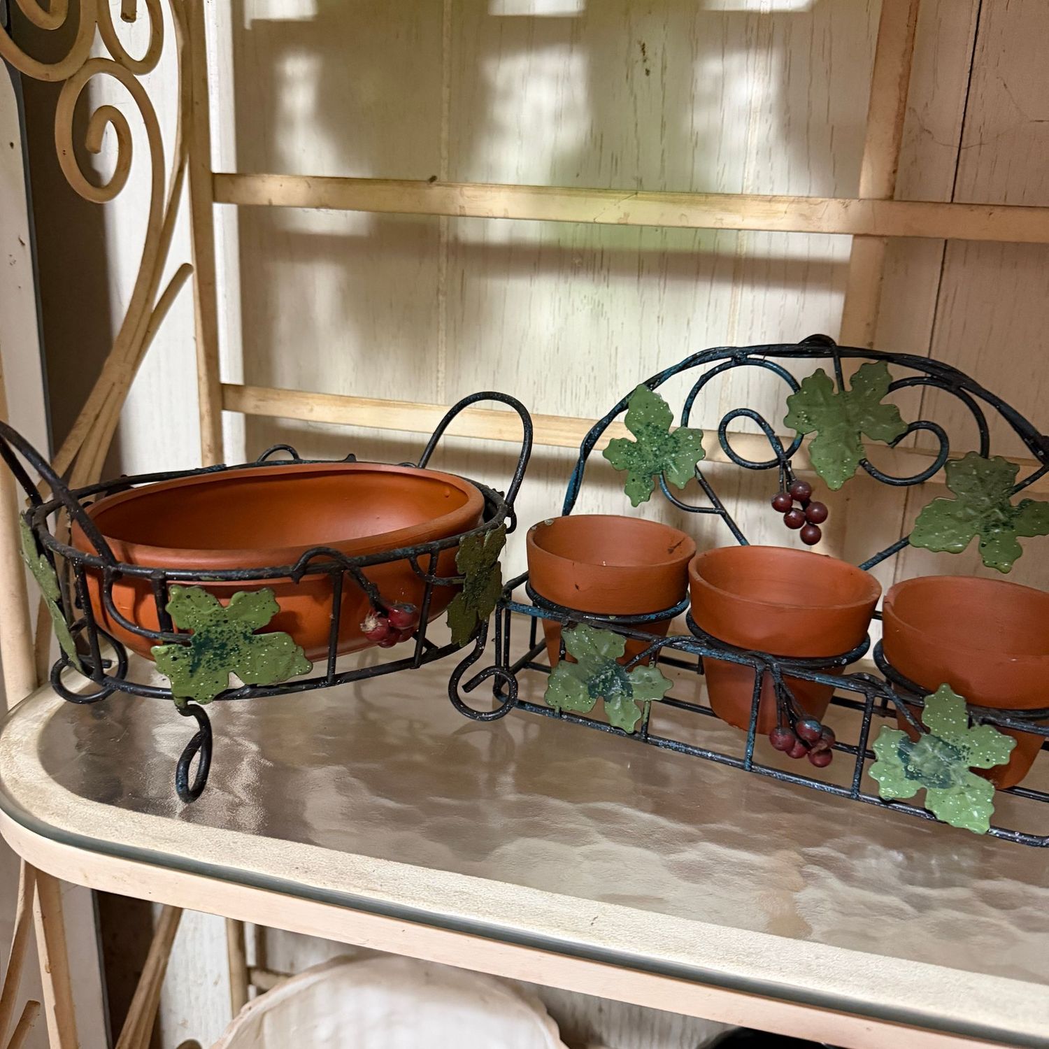 Terracotta planters in metal grape vine stands, the widest is 9"