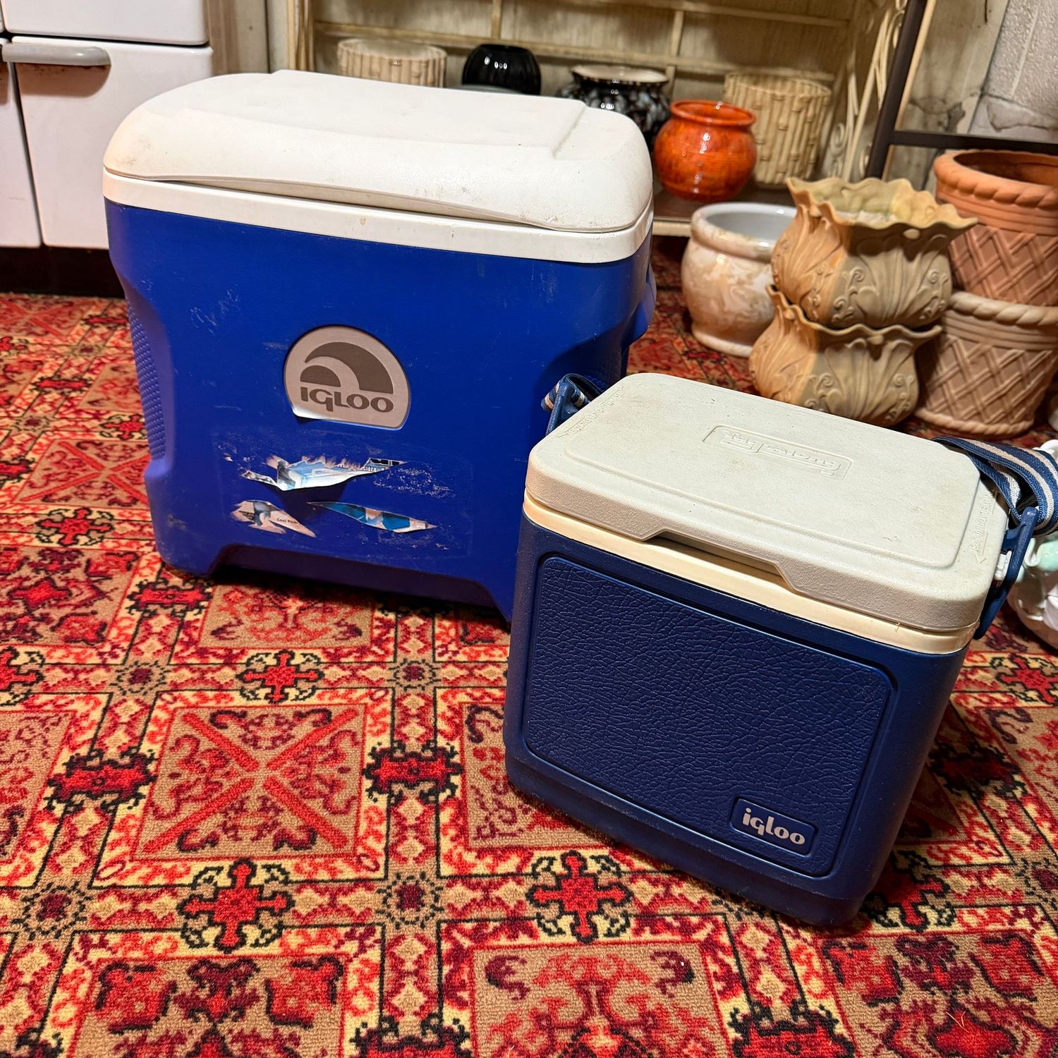 Two blue Igloo coolers, some wear, the largest is 16"L