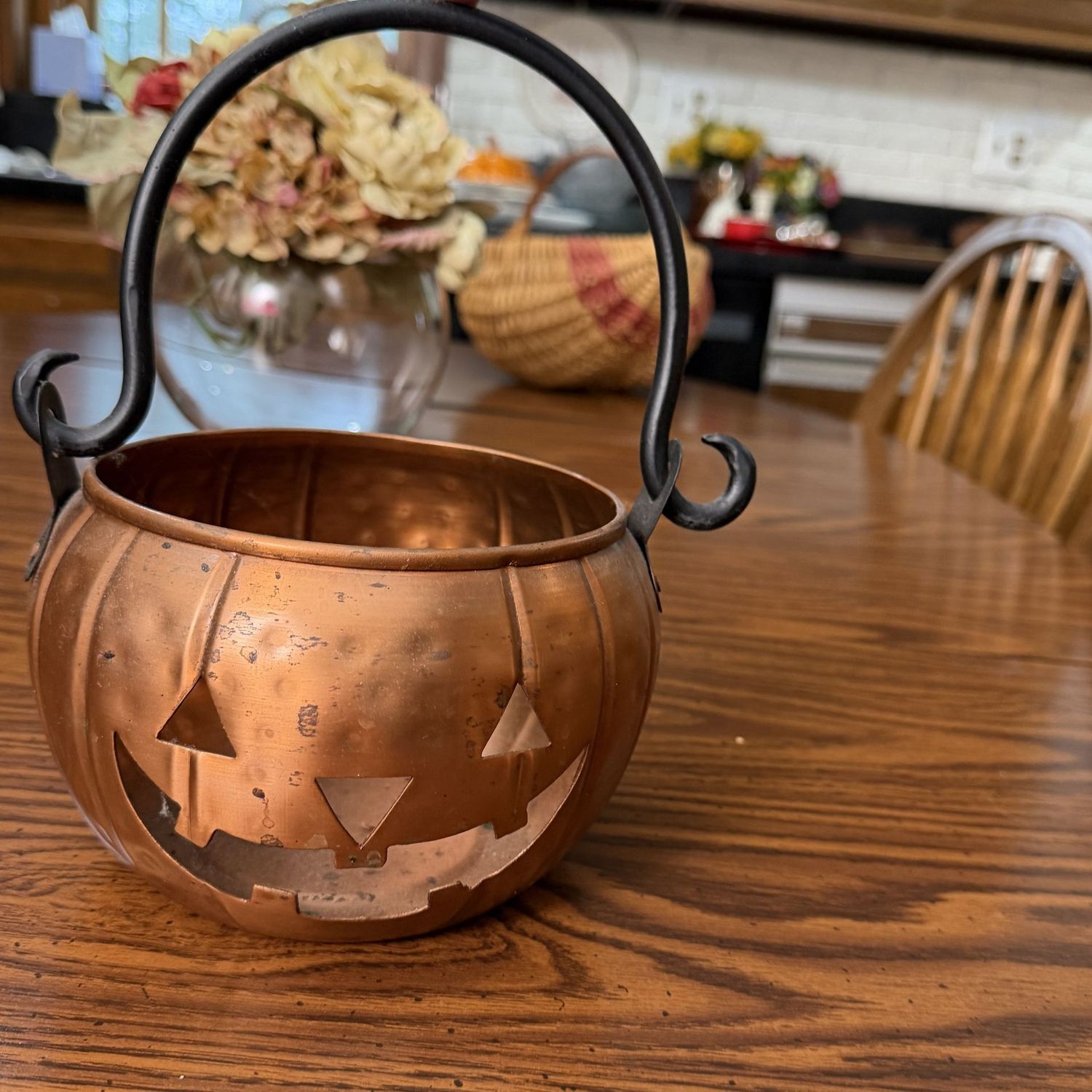 Metal pumpkin luminary with copper finish, an iron handle, 8"W