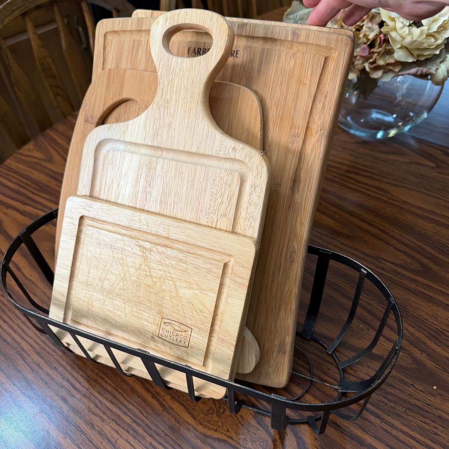Group of cutting boards (some wear) in an oval metal basket, the largest board is 10" x 13"