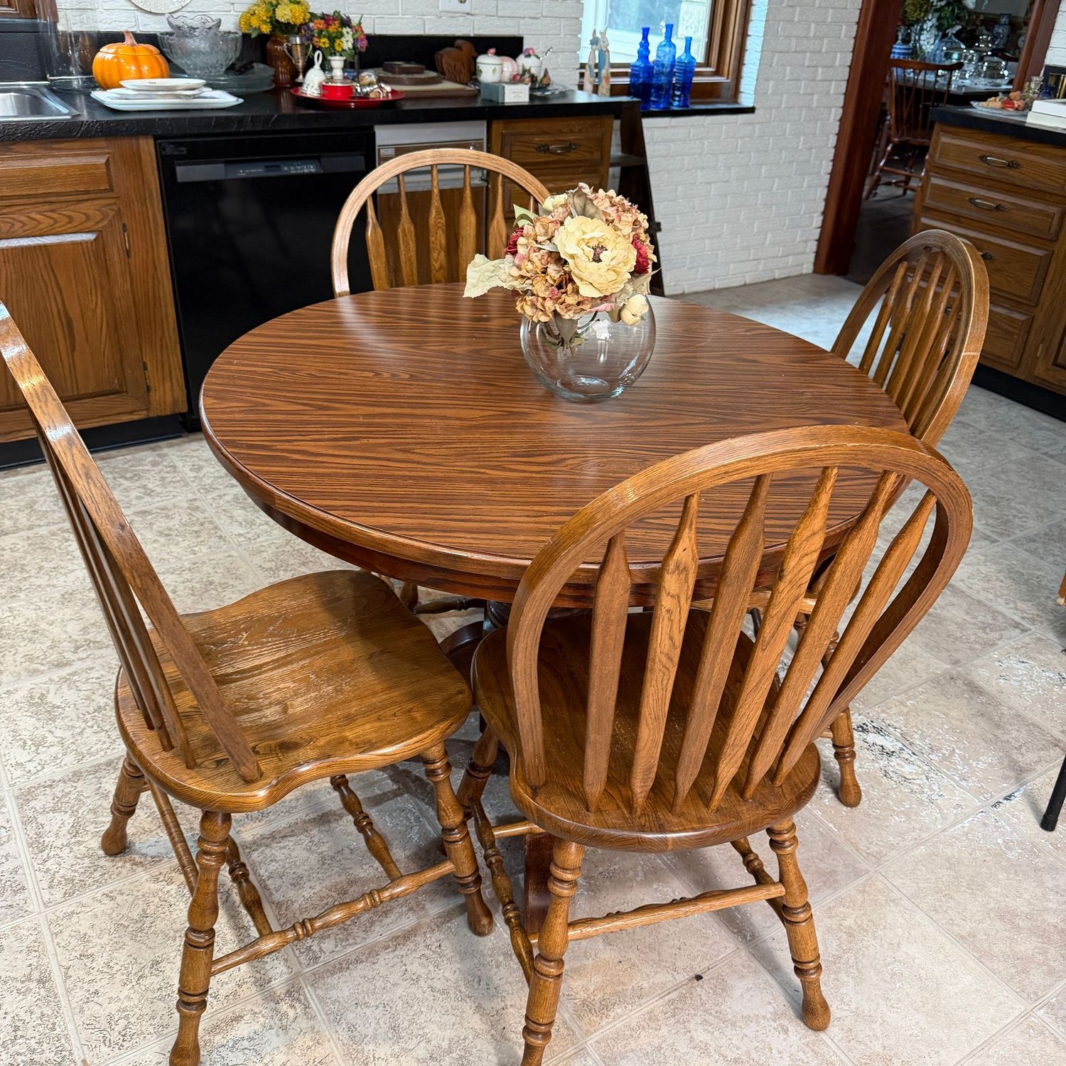 Round-to-oval kitchenette table with pedestal let, 4 chairs, 2 leaves (do not fit tightly), some wear to all, 40" round, 63" with leaves inserted