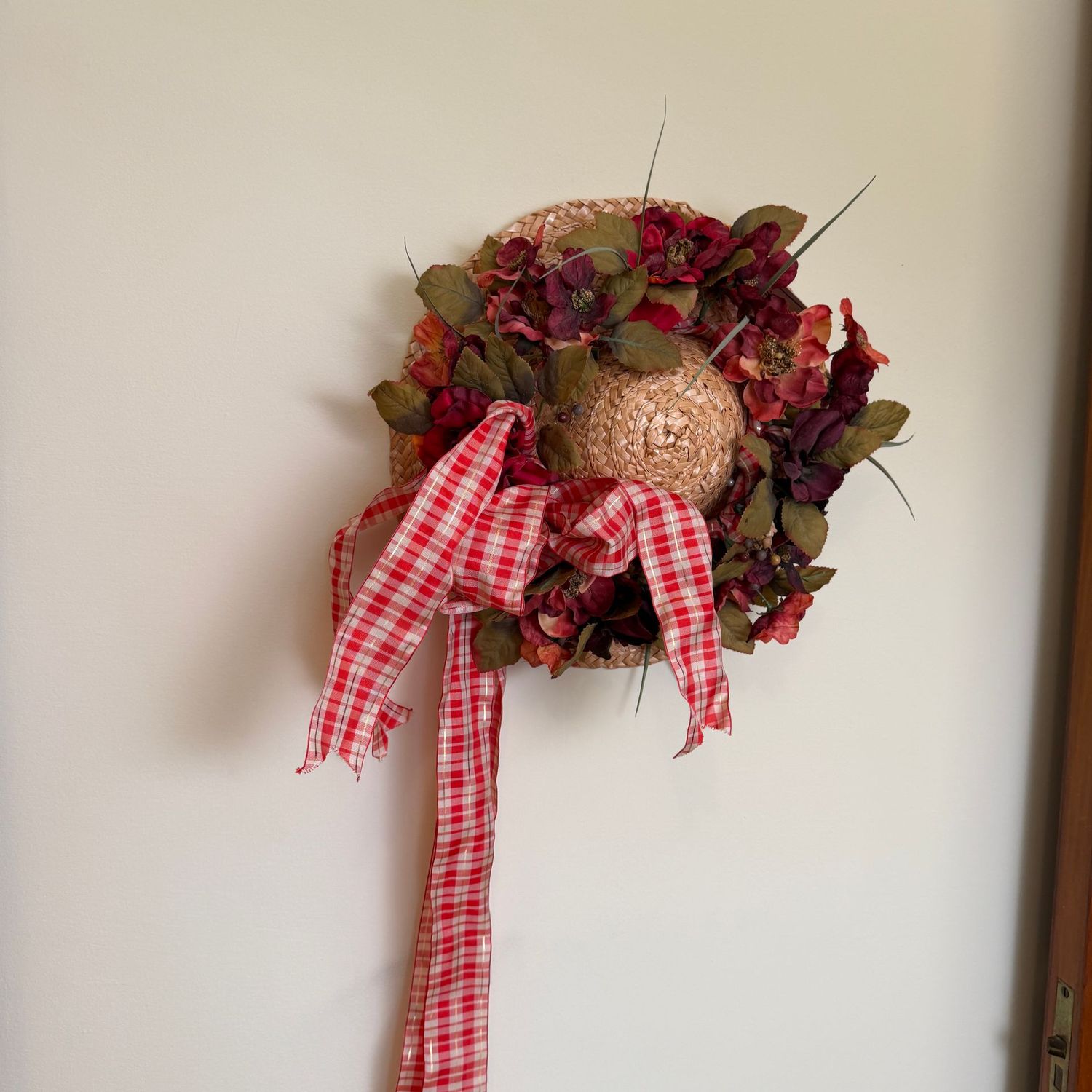 Straw bonnet hat with long red plaid ribbon, deep red floral band. The hat is 14"W