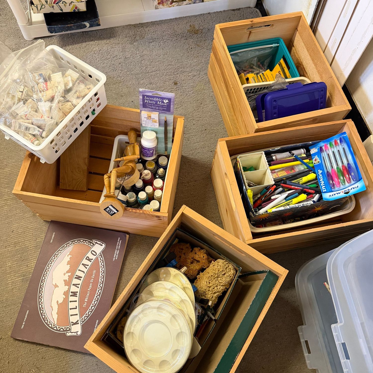 Four wooden boxes filled with artist supplies, some are new, some are used