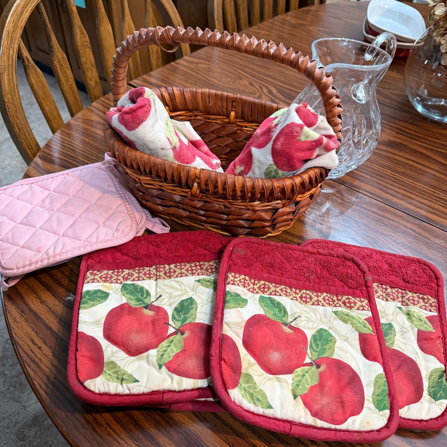 Woven basket with vintage pot holders & towels, some wear to all, the basket is 12"W