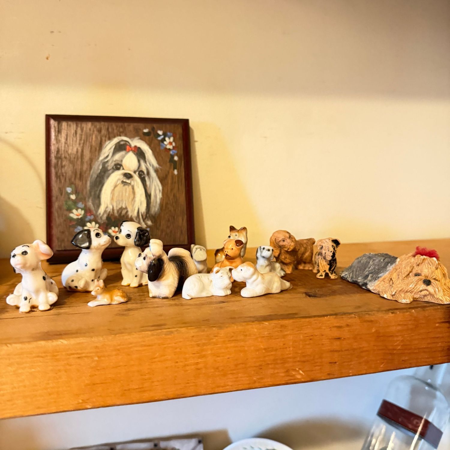 Collection of porcelain and resin dog figurines, 3/4" to 2" and wooden dog plaque