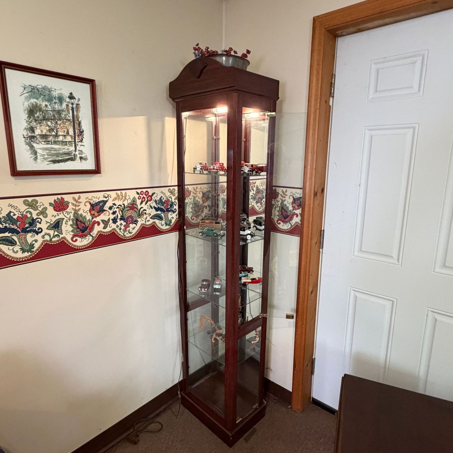 Lighted cherry laminate slender curio cabinet, adjustable glass shelves, a few scratches (mostly at bottom) 6'3 Lighted cherry laminate slender curio cabinet, adjustable glass shelves, a few scratches (mostly at bottom) 6'3"H x 16"W x 12"D (This item is heavy and in the lower level - OK to use a dolly)