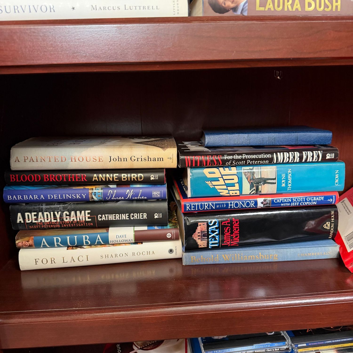 Shelf of books including A Painted House, For Laci, Texas