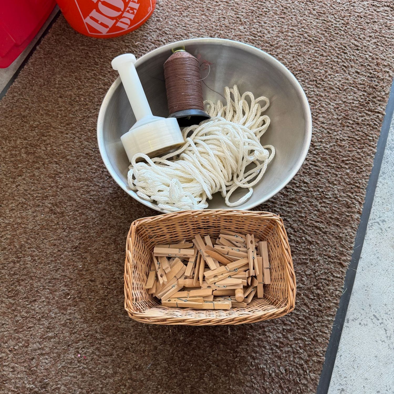 Large metal bowl with string, cord, plastic stretch wrap, and basket of clothespins