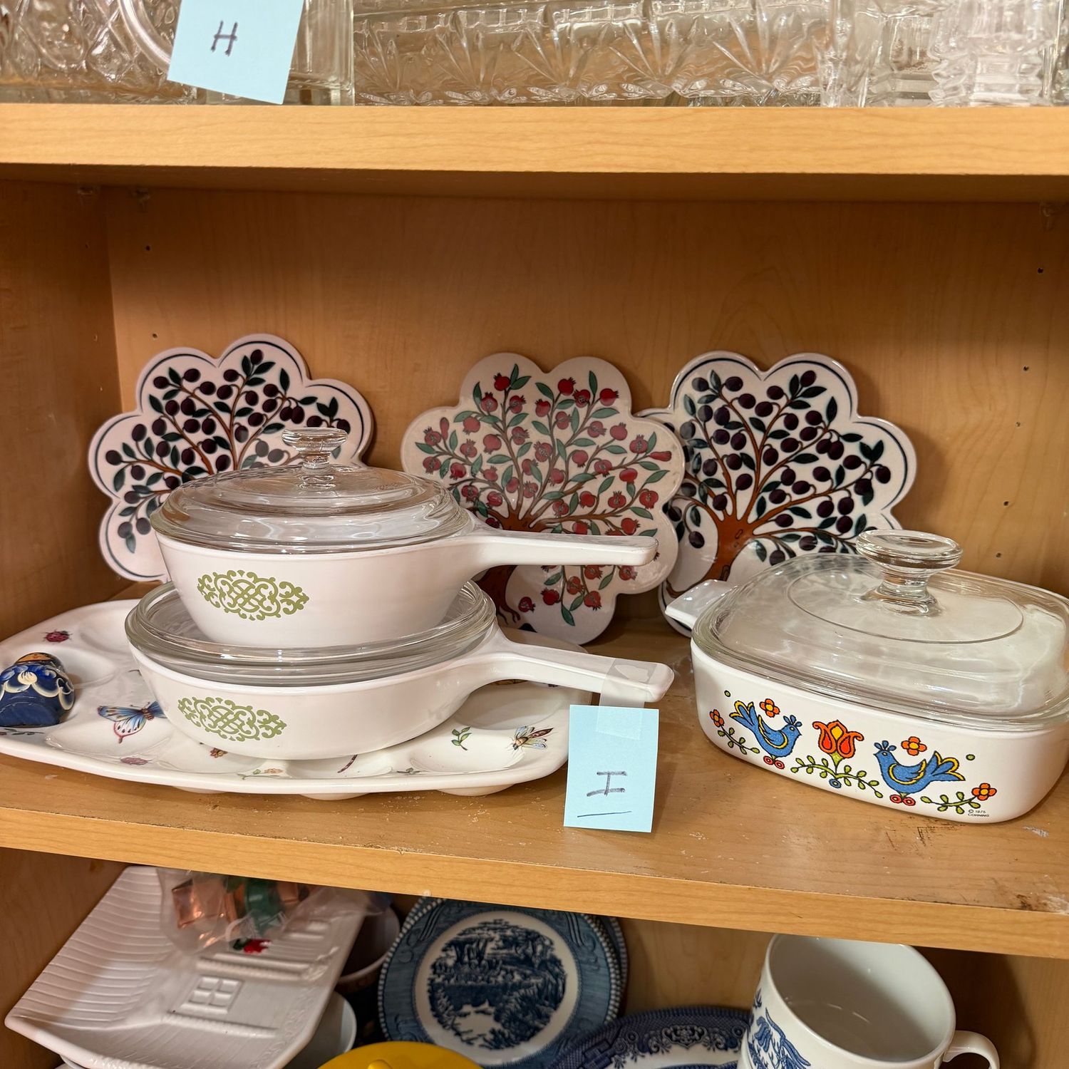 Kitchenware Lot I, tree trivets, egg dish, Corningware Country Festival casserole, and Medallion covered pans