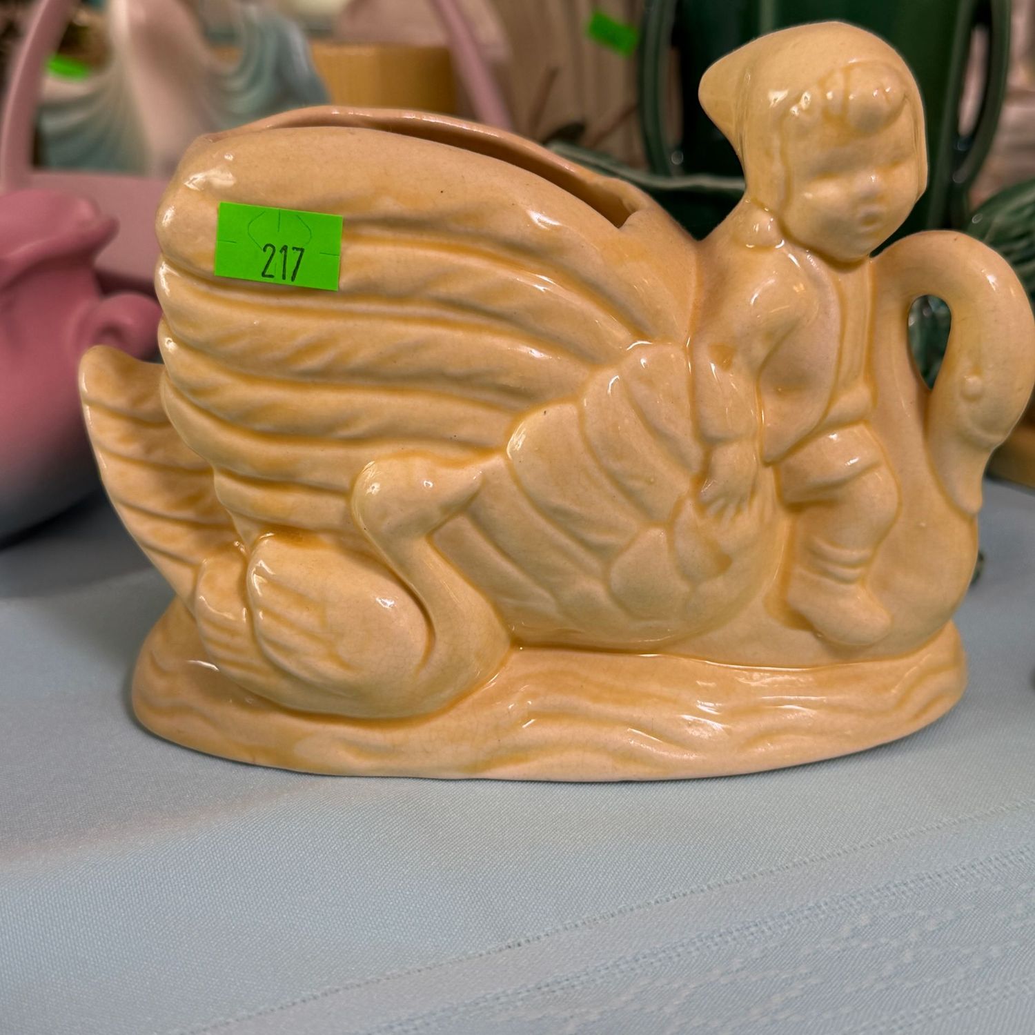 Lot #217, yellow pottery planter, child, gnome, riding swan, 6.5"L
