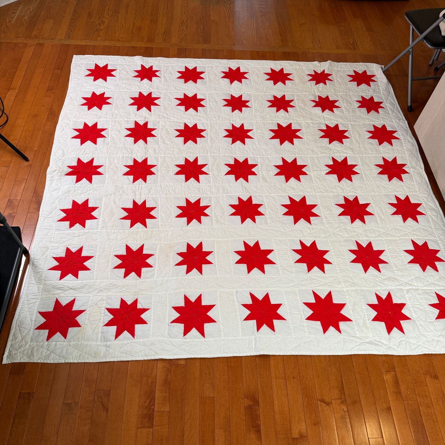 Red sawtooth star quilt with white backing, appears all hand-stitched, 6'6" x 6'10"