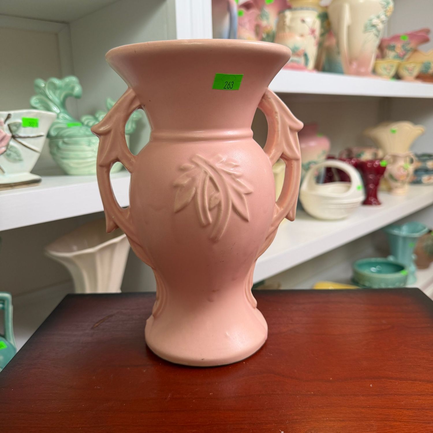 Lot #263, pink McCoy pottery, embossed, branch-handle vase, minor hairline near handle, small chip under lip, 7.5"