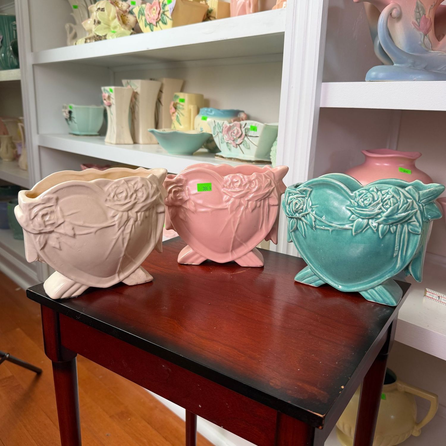 Lot #386, set of McCoy pottery ivory, pink, and teal heart-shaped vases, planters, 5"H x 5.75"W