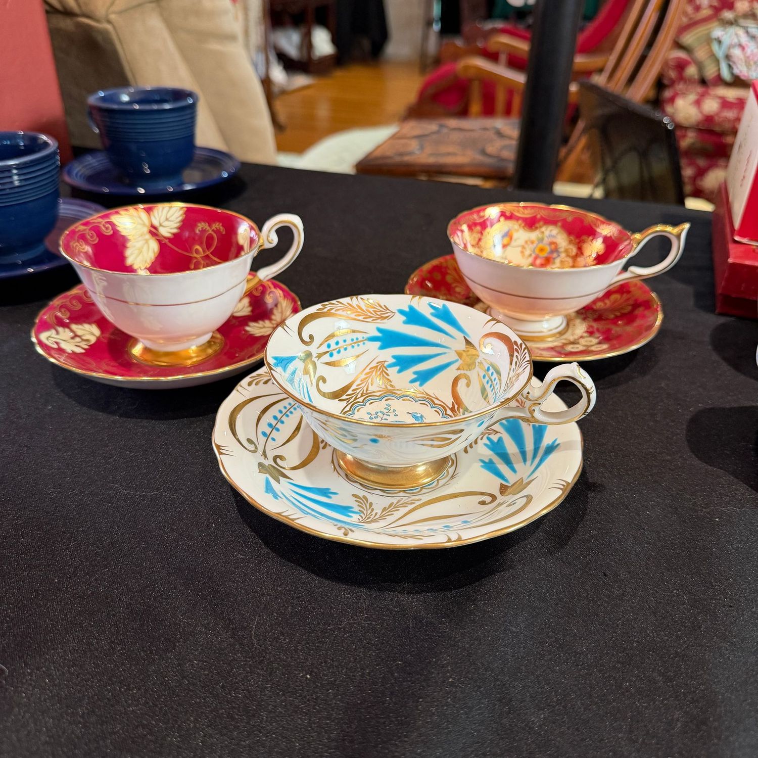 Three porcelain teacups with gold embellishments Three porcelain teacups with gold embellishments