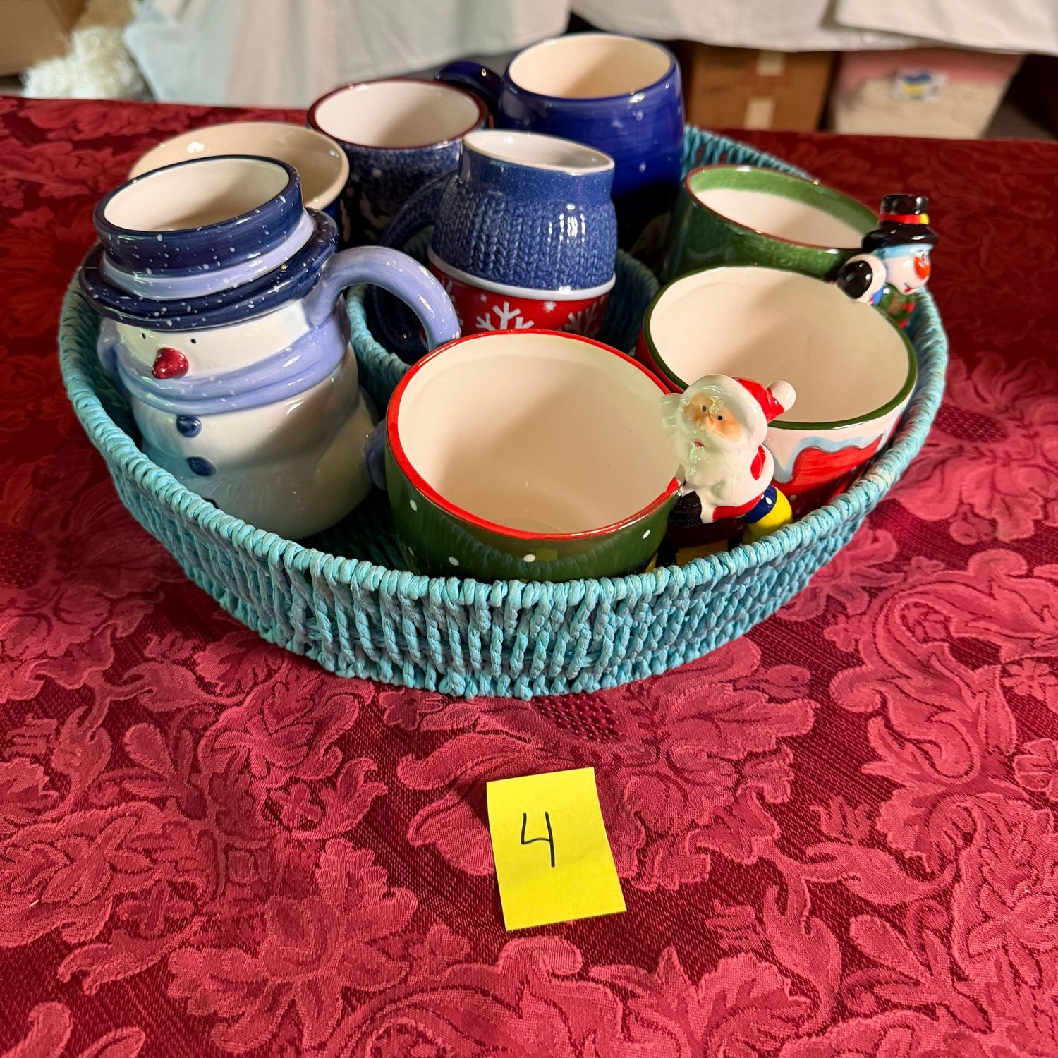 Lot #4, blue basket with Christmas-themed mugs Lot #4, blue basket with Christmas-themed mugs