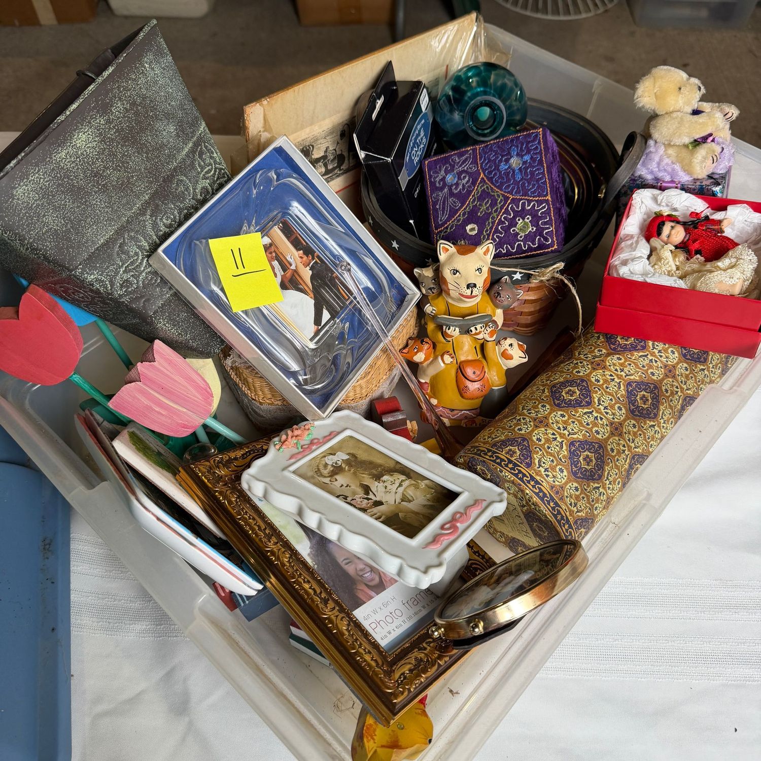 Lot #11, bin of decorative items including wooden tulips, frames, basket Lot #11, bin of decorative items including wooden tulips, frames, basket