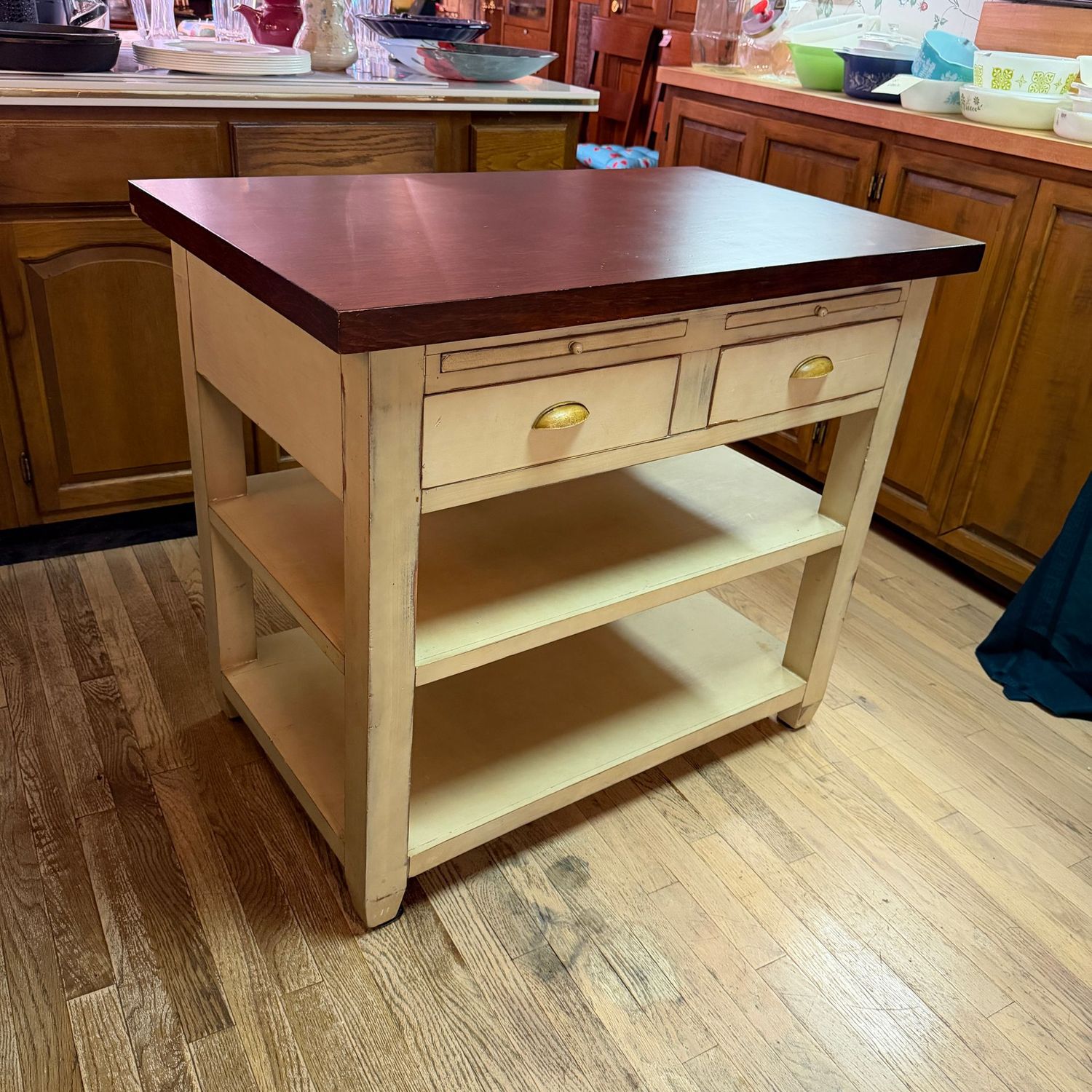 Kitchen island with walnut-finished veneer top, distressed cream finish on base with pull-out shelves, drawers, sturdy, has a 6 Kitchen island with walnut-finished veneer top, distressed cream finish on base with pull-out shelves, drawers, sturdy, has a 6" area on side of top with loose veneer, 34"H x 23"W x 39"L