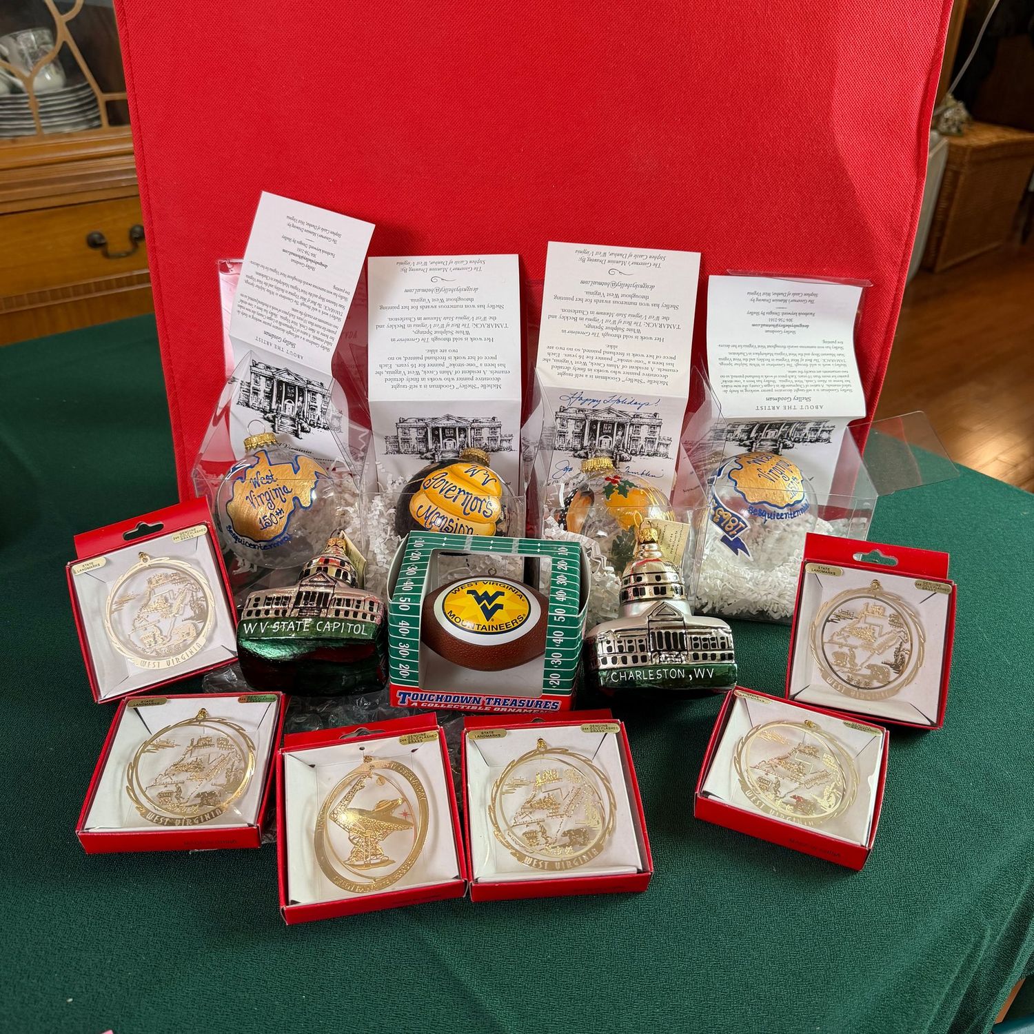 Packed bin of West Virginia ornaments, state landmarks,  Green Bank, Glass state capitol, Goodman ornaments, one is signed by 1st Lady Tomblin, S1450