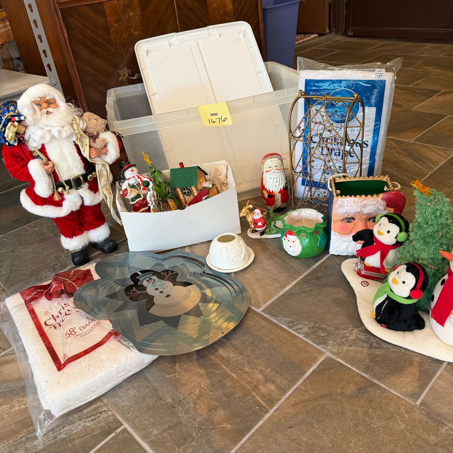 Clear bin filled with Christmas decor, Santa, snow drape, ornaments, wine bottle holder & more, S1676