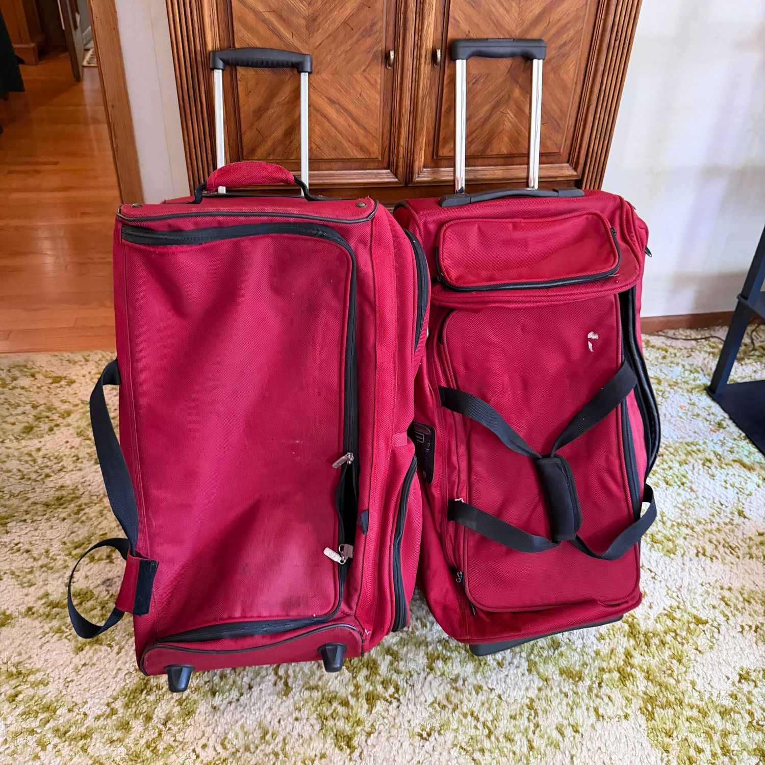 Two large red duffle bag, rolling, one is missing a carrying strap (not essential if rolling), some wear to the exterior, 27 Two large red duffle bag, rolling, one is missing a carrying strap (not essential if rolling), some wear to the exterior, 27" x 18", S1710