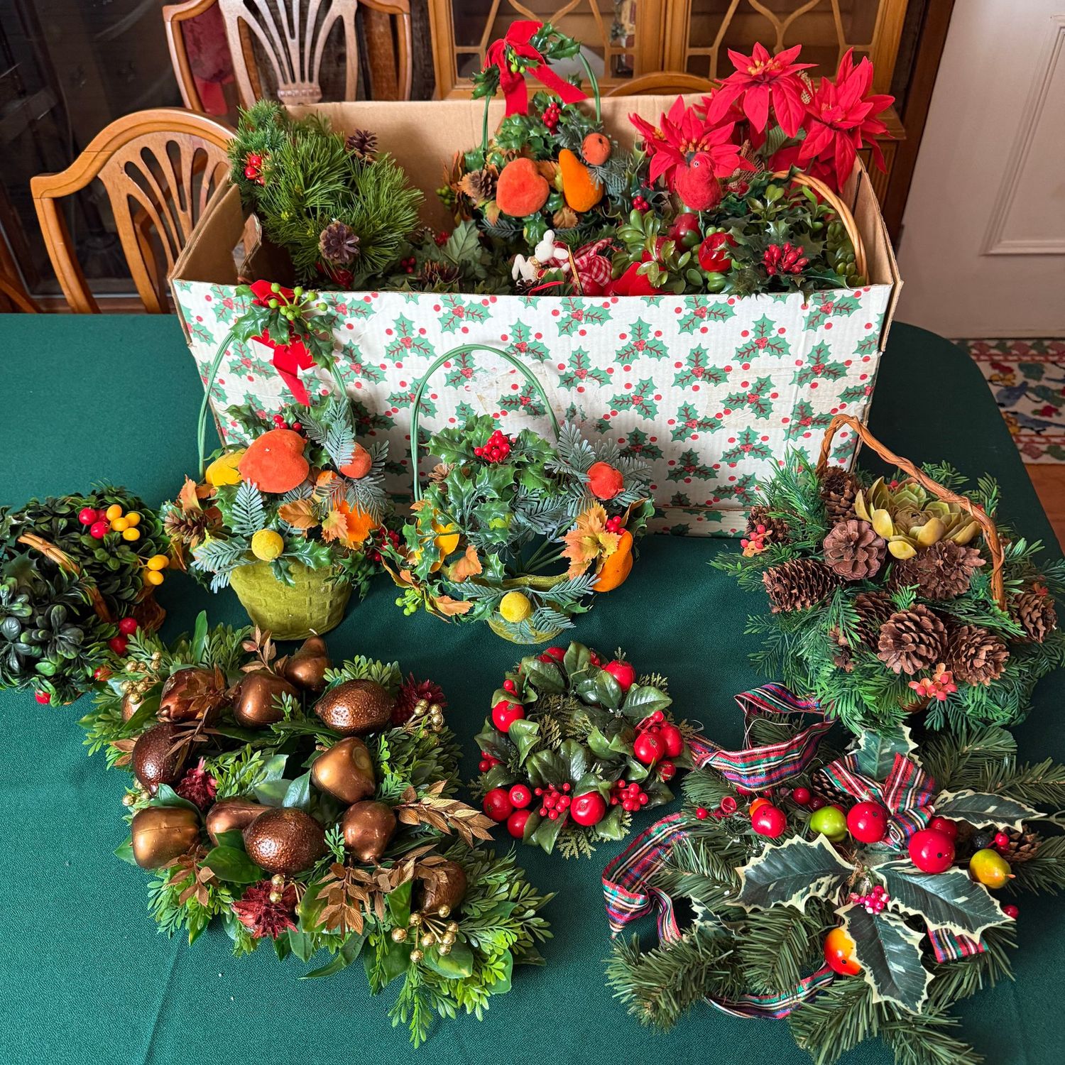 Cardboard box filled with vintage-style greenery, candle rings, decorative baskets, S1855