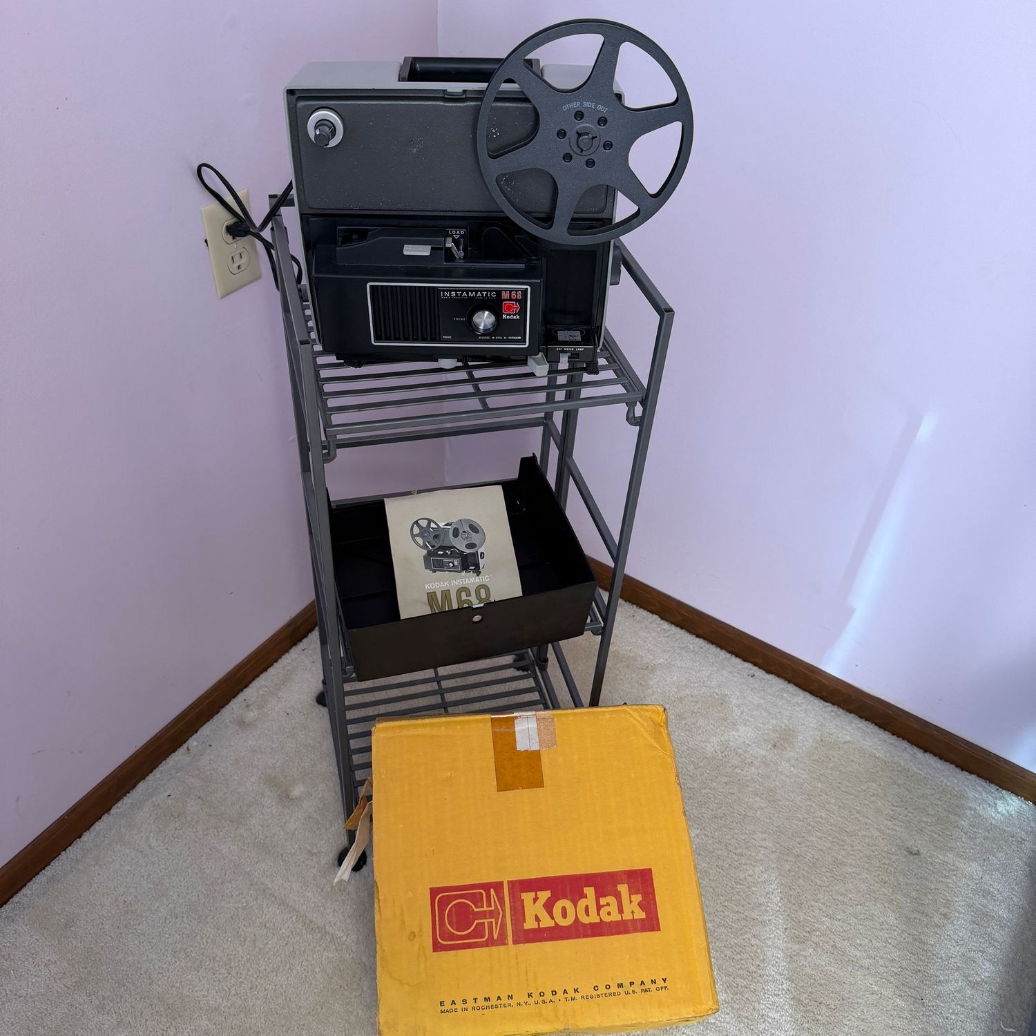 Eastman Kodak M68 Instamatic projector, appears nearly unused, minor wear to pad feet, lights up and runs quietly, box shows some wear mostly on the bottom
