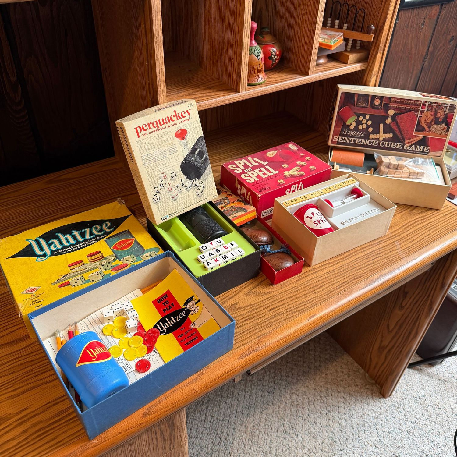 Group of games including Yahtzee, Spill & Spell, scrabble, with game pieces seen, 1970s Group of games including Yahtzee, Spill & Spell, scrabble, with game pieces seen, 1970s