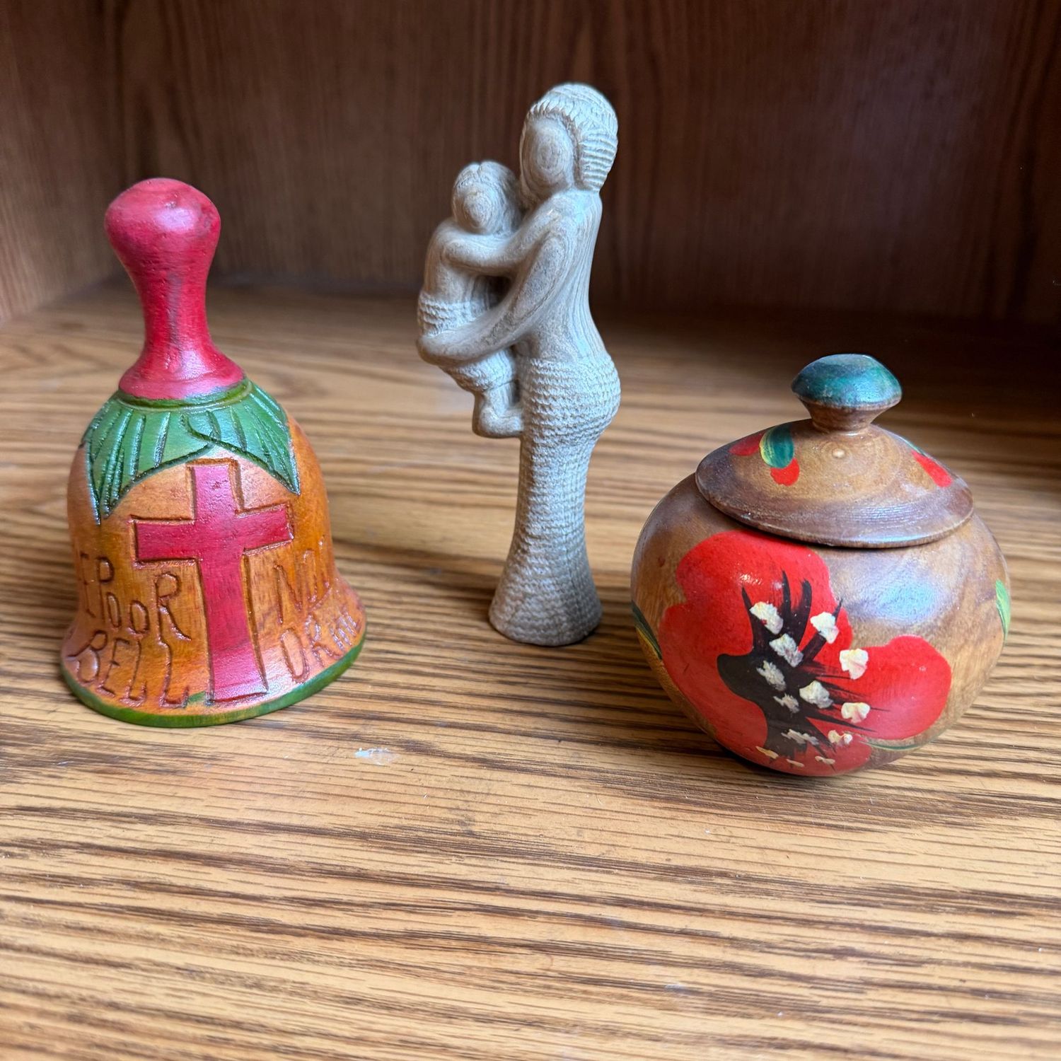Decorative grouping of carved bell, figure, jar