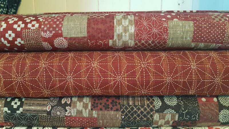 Japanese Cotton print fabric  by Sevenberry. Patchwork design print in  reds, cream and  maroon.