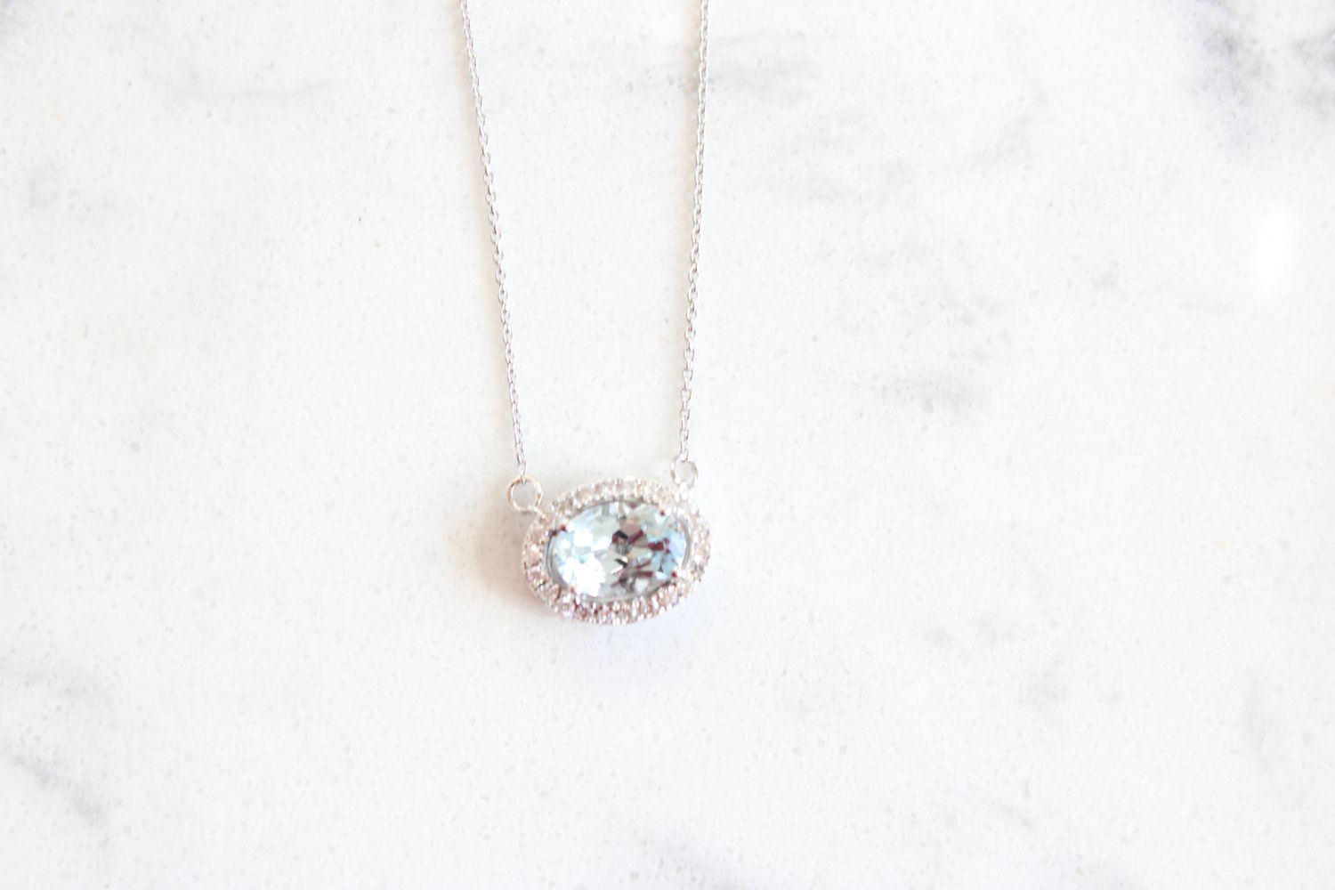 14kt White Gold .09ct Diamond .72ct Oval Aquamarine Halo East to West Necklace