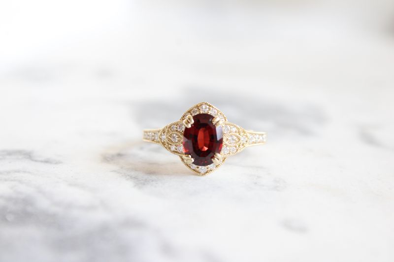 14kt Yellow Gold Oval Garnet with Vintage Inspired Halo, 30 Round Diamonds at .23ct Total 14kt Yellow Gold Oval Garnet with Vintage Inspired Halo, 30 Round Diamonds at .23ct Total