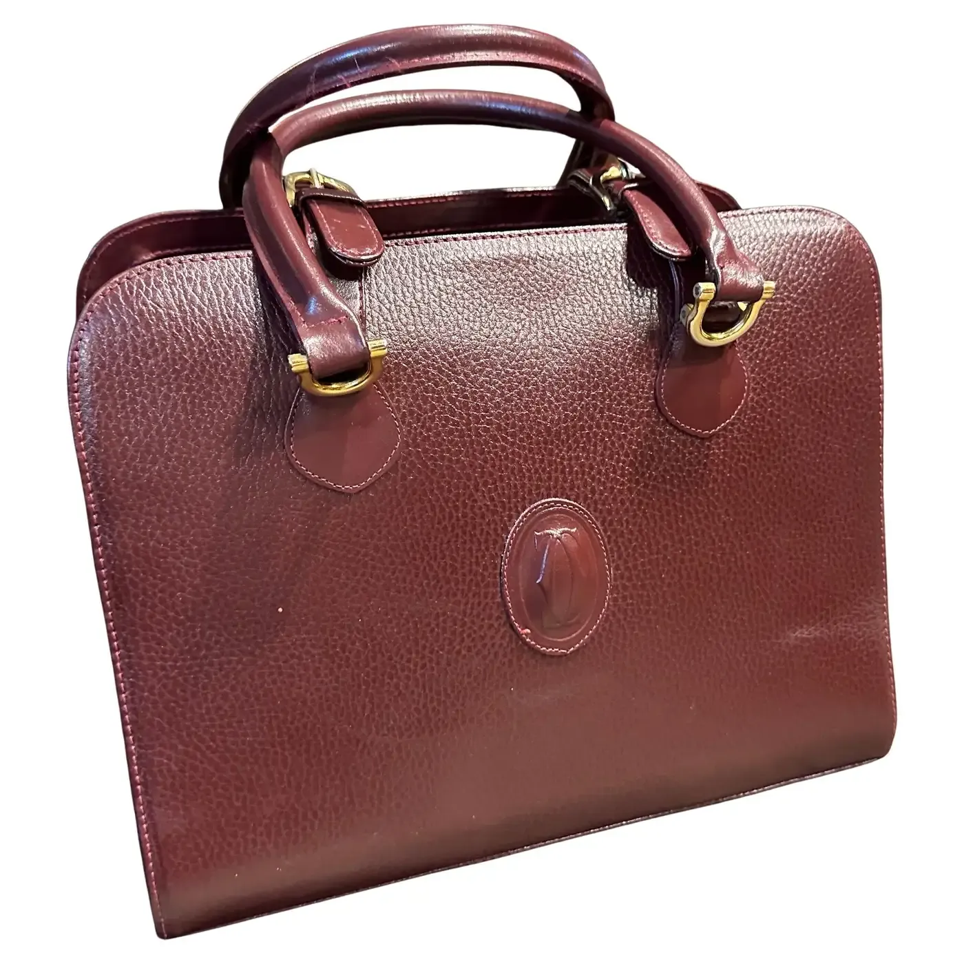 A 1990s Elegant Bordeaux Leather and Brass Top Handle Bag by Cartier
