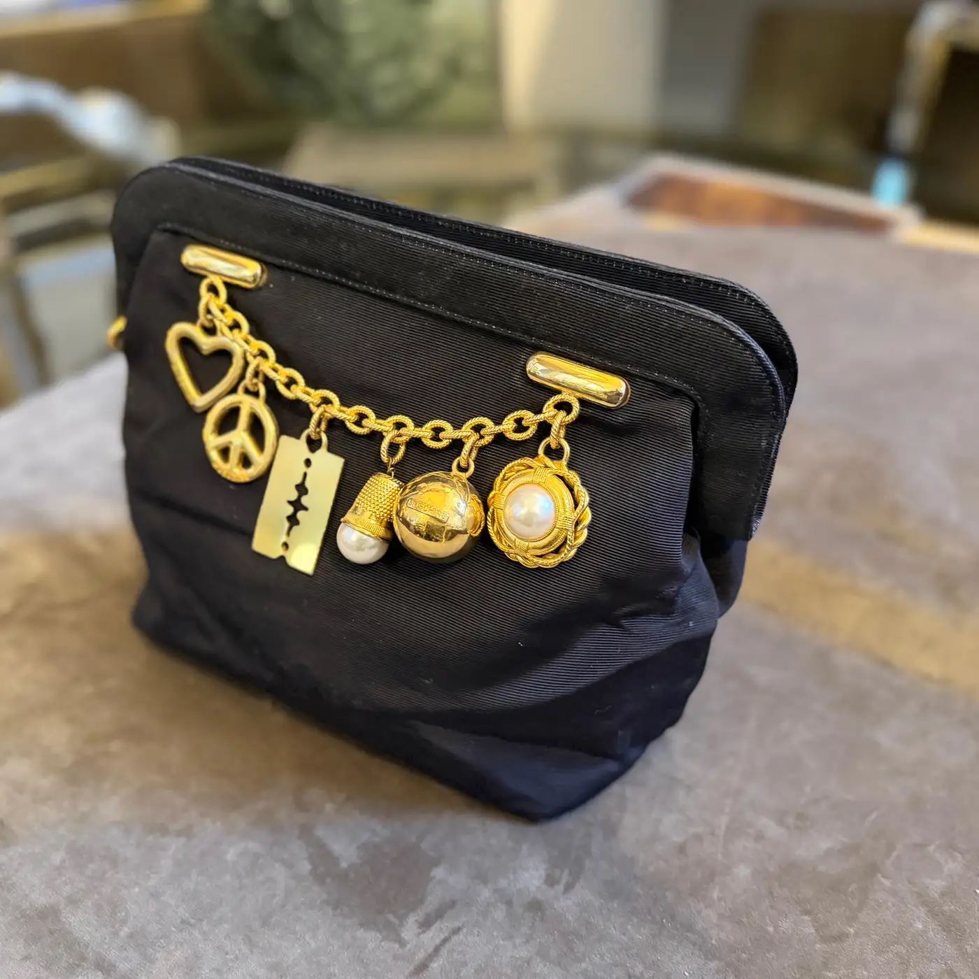 1980s Iconic Black Fabric and Brass Charms Clutch by Franco Moschino
