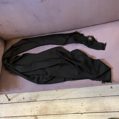 A Never Used Black Wool Scarf by Gucci with Continuous Logo