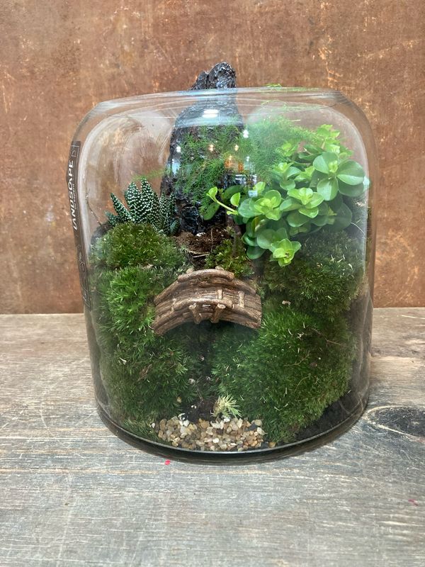Centre ampolla de vidre decorada amb plantes i pont i ..,