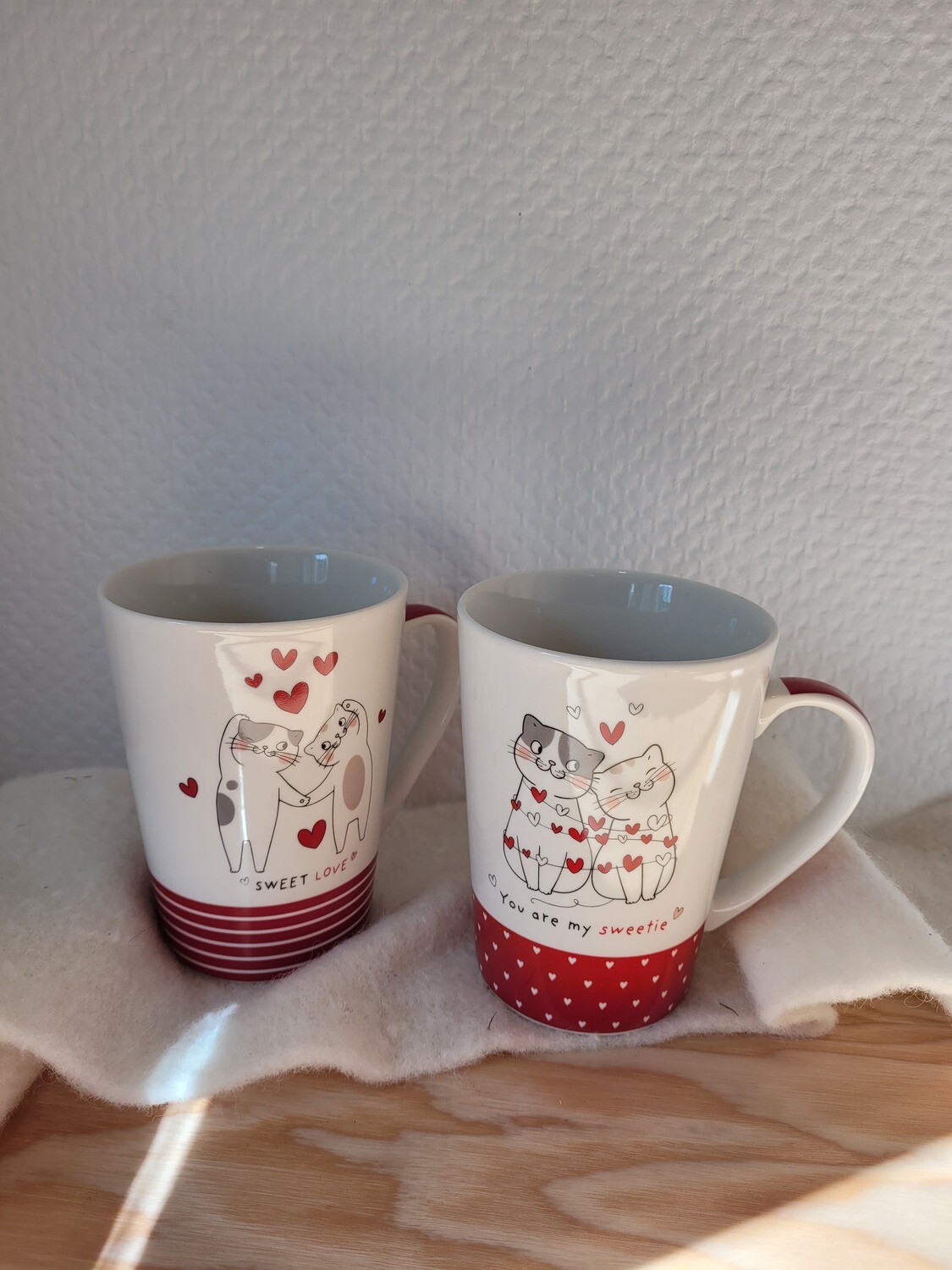 Tasse blanche et rouge chats qui sont assis collés