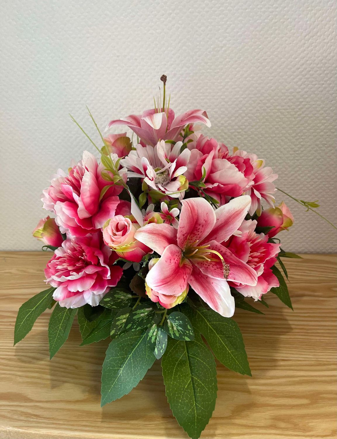 Coussin  de fleurs artificielles dans les tons roses