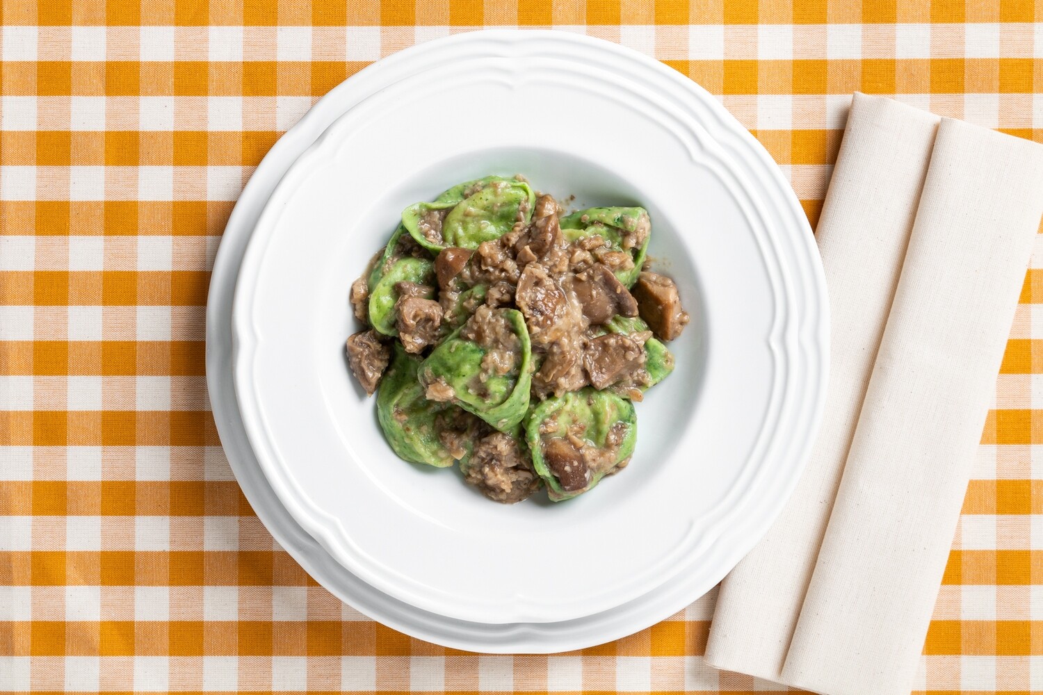 Tortelli verdi ripieni di patate e salsiccia con funghi porcini e funghi misti Tortelli verdi ripieni di patate e salsiccia con funghi porcini e funghi misti